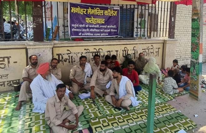 Employees staged a sit-in protest outside the college against being fired, expressing anger