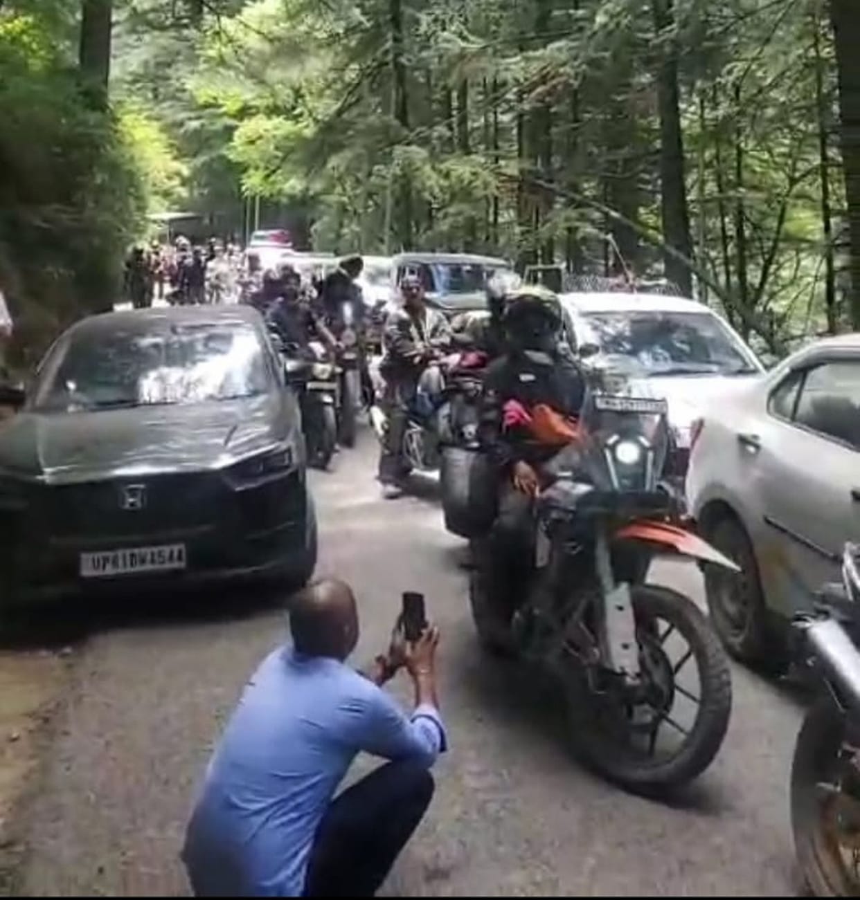 Tourists parked their vehicles on the highway and went out for a walk, causing a traffic jam.
