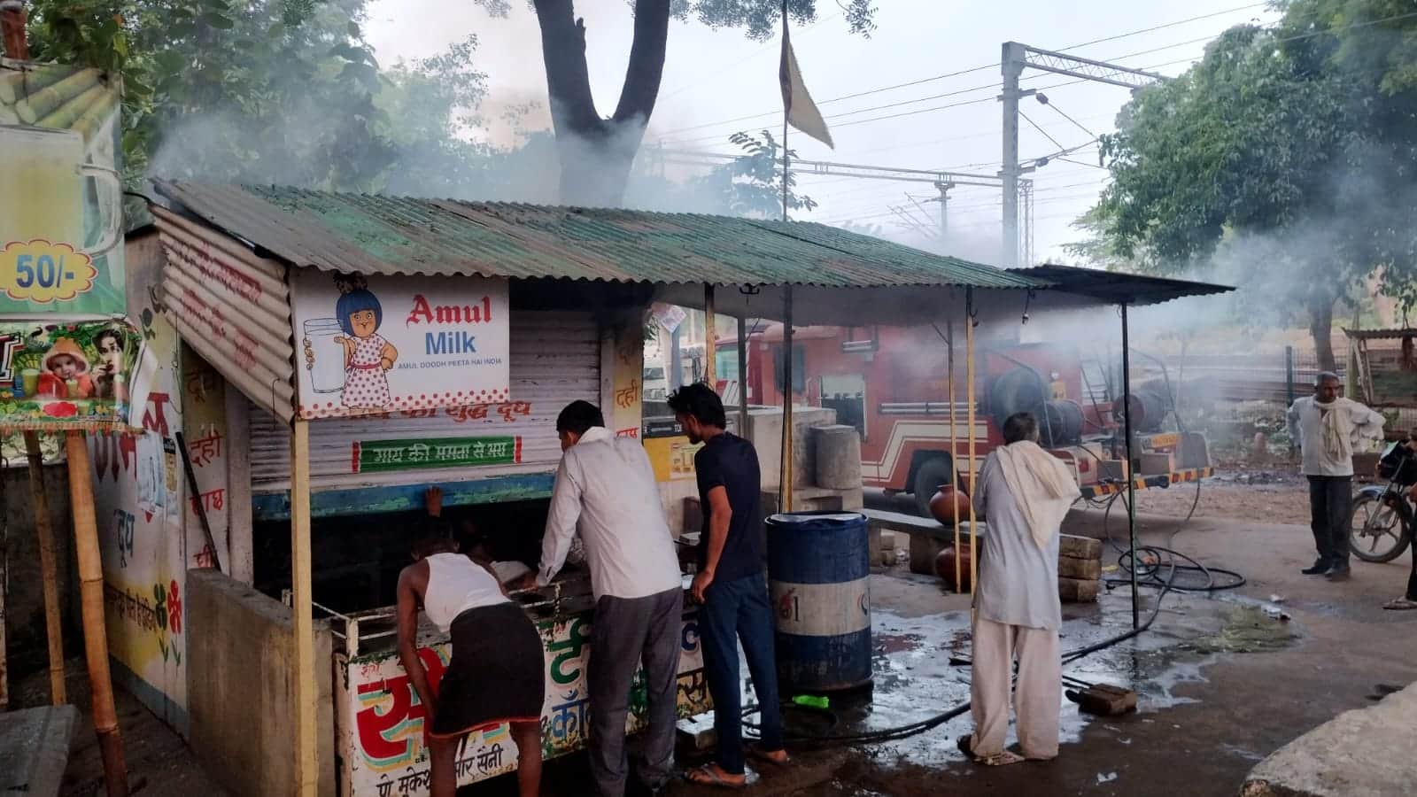 कन्फेक्शनरी की दुकान में लगी आग को बुझाते दमकल कर्मी। संवाद