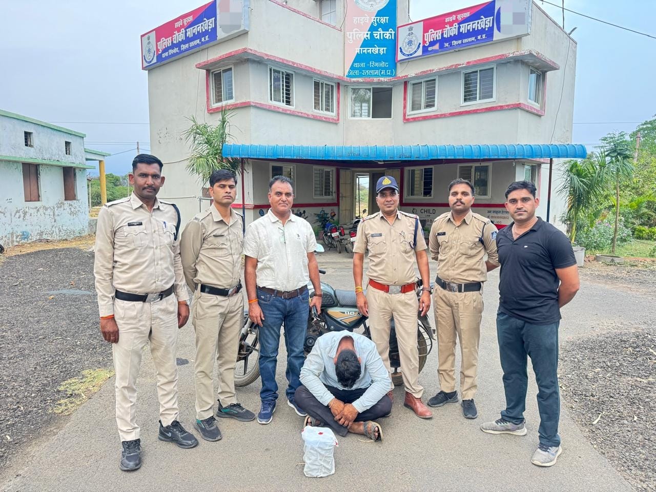 पुलिस गिरफ्त में नीचे मुंह करके बैठा अफीम तस्करी का आरोपी