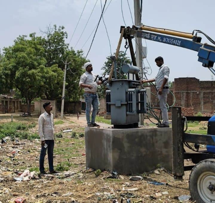 फोटो-14-फतेहपुर खालसा में फुंके ट्रांसफार्मर को बदलते कर्मचारी। संवाद