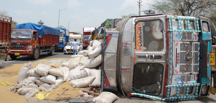 Wheat-laden truck overturns after going out of control near a speed breaker.