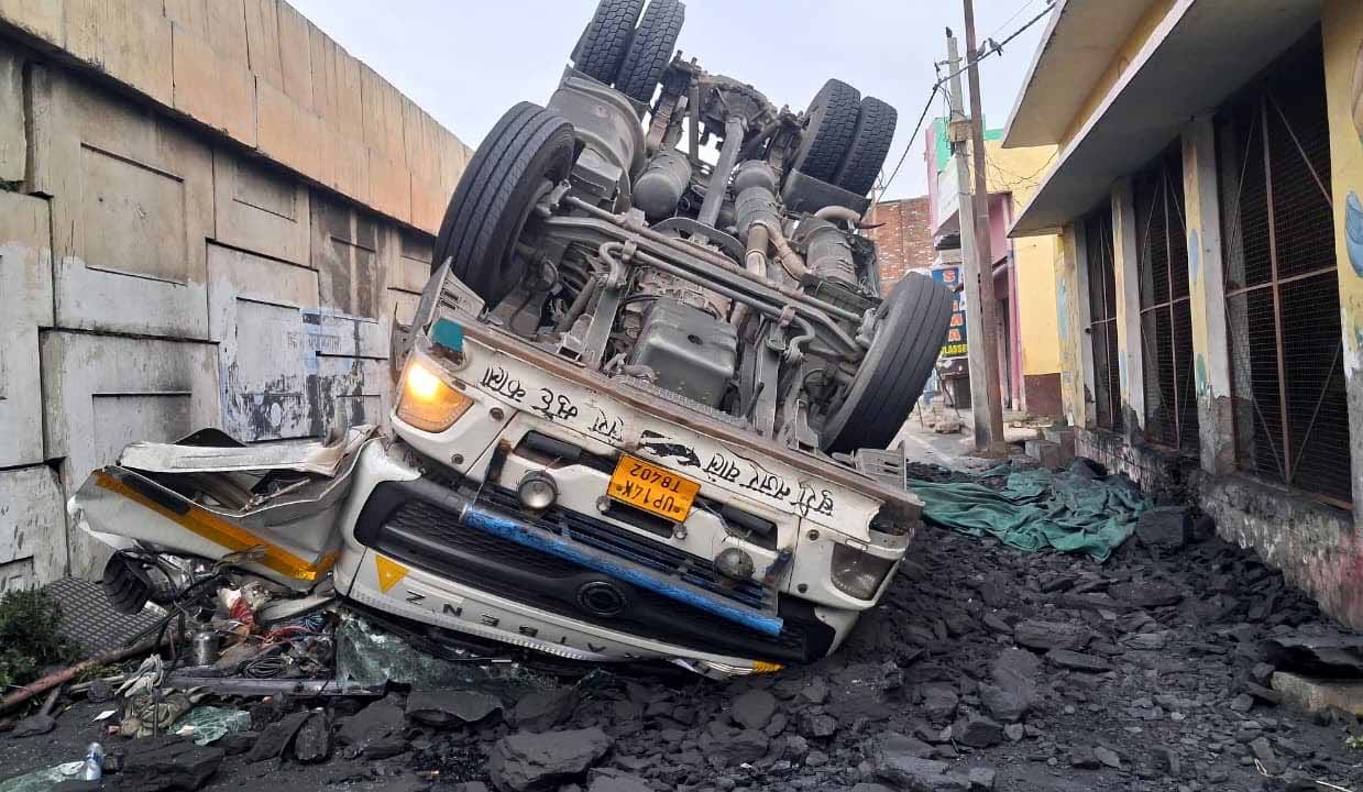 Coal-laden truck falls off bridge; driver and helper injured.