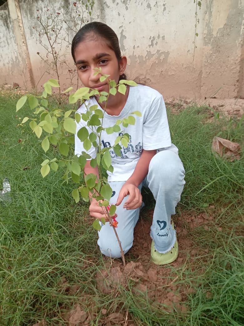 Student Parul is spreading the message of environmental protection by planting trees.