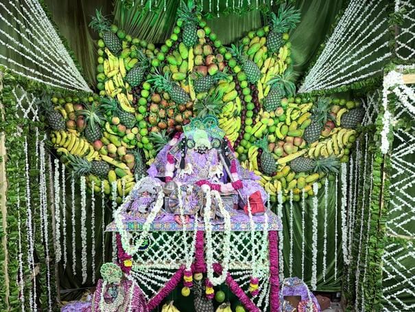 Mathuradhish sits in a flower bungalow decorated with fruits.