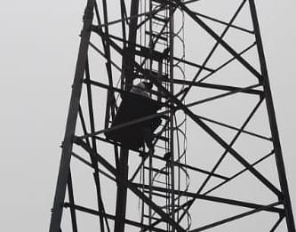 Youth climbs mobile tower to demand widening of the road.