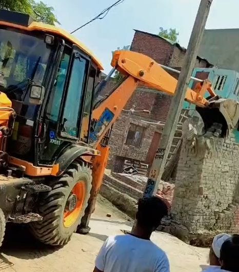 Bulldozer used to demolish illegal construction at the Holika Dahan site in Ikri village.