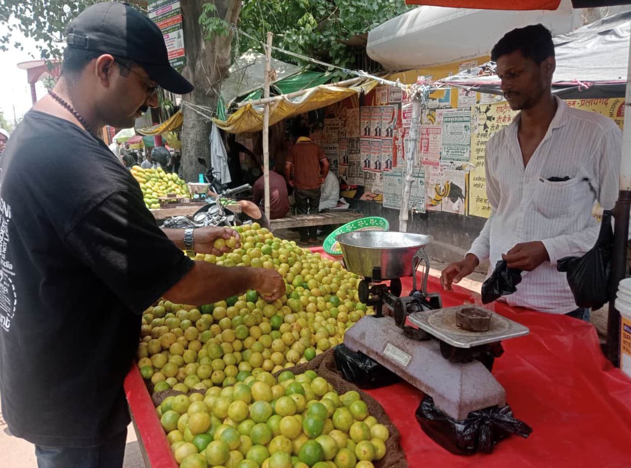 कचहरी के बगल दुकान पर नींबू खरीदता ग्राहक। संवाद