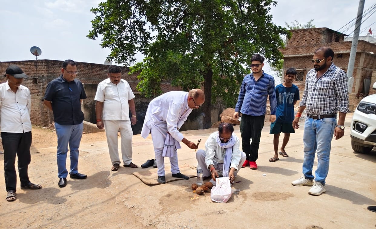 The chairman inaugurated the road construction work by breaking a coconut.