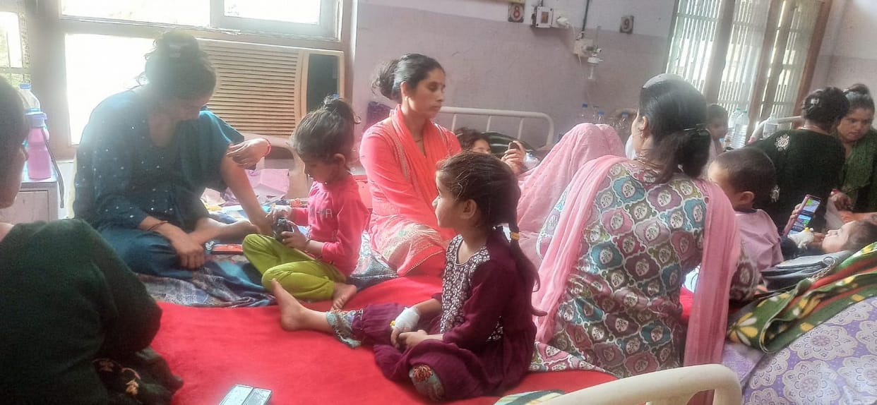 Medical college's pediatric ward packed with children; beds fall short.