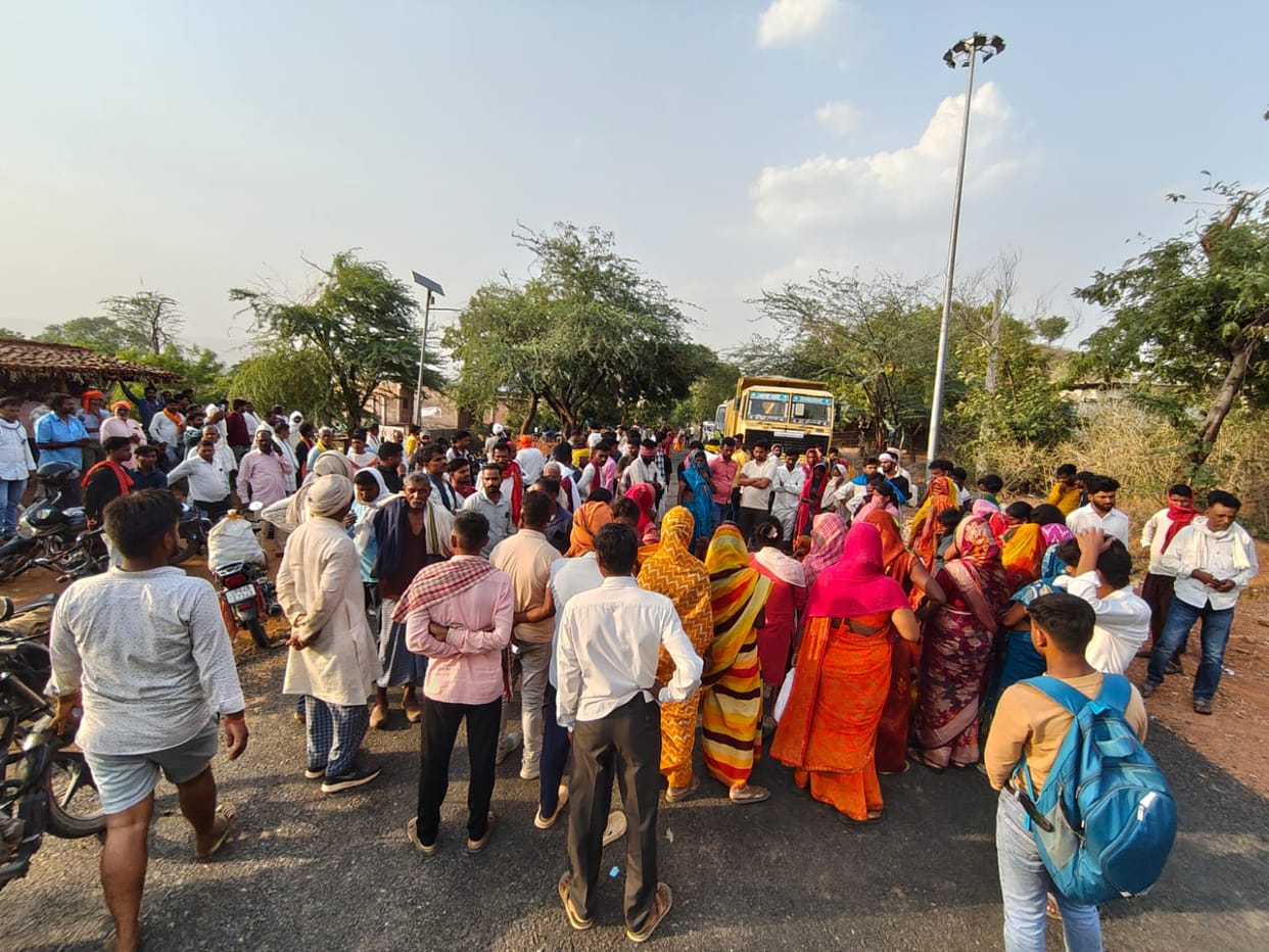 Teenager dies after coming into contact with a sagging high-tension wire in a field; angry locals block the road with the body.