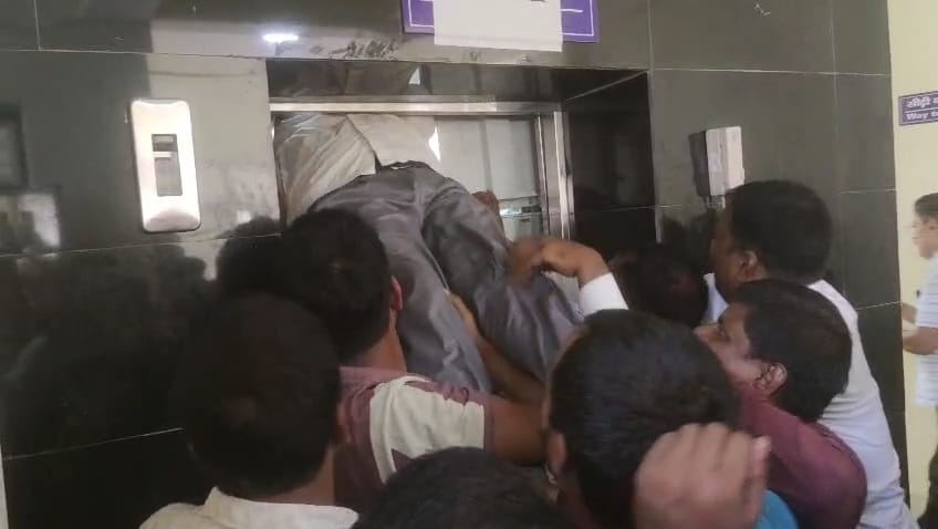लिफ्ट में फंसे लोगों को बाहर निकालते लोग