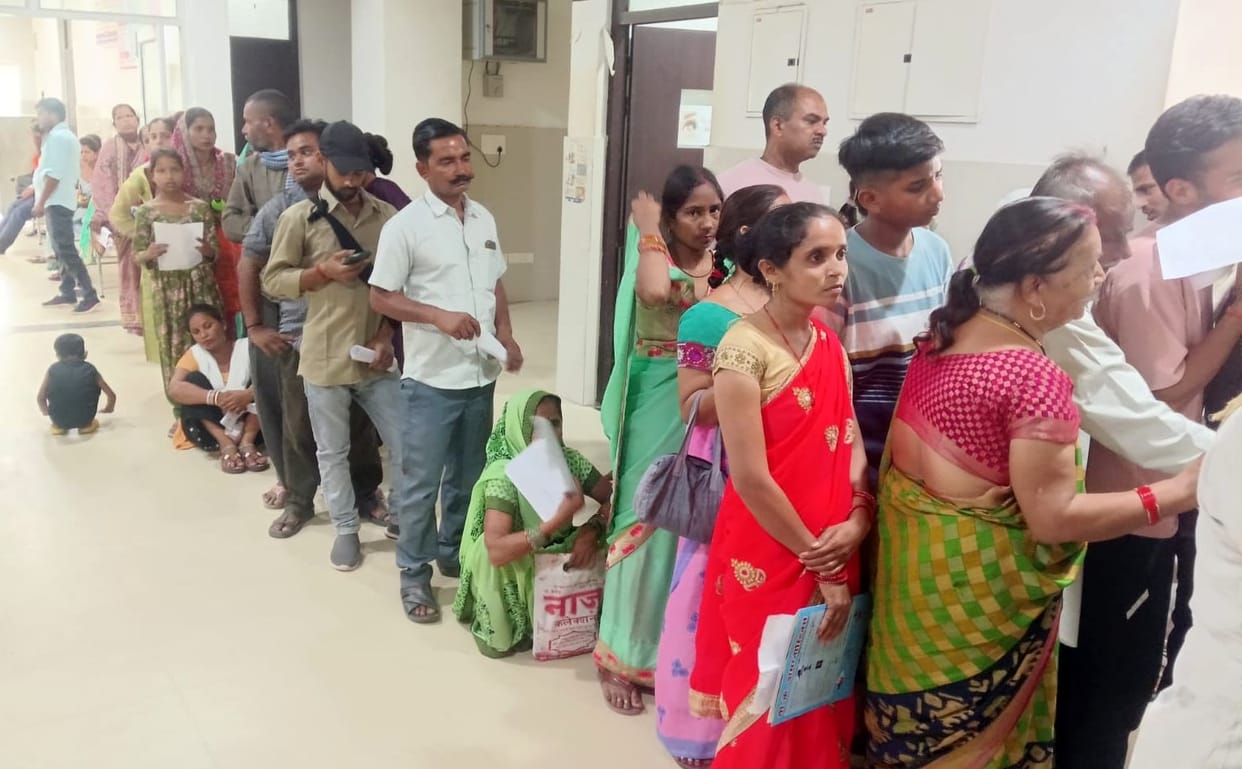 Twenty patients are being seen in ten minutes; the doctor writes the prescription before the patient can even describe their pain.