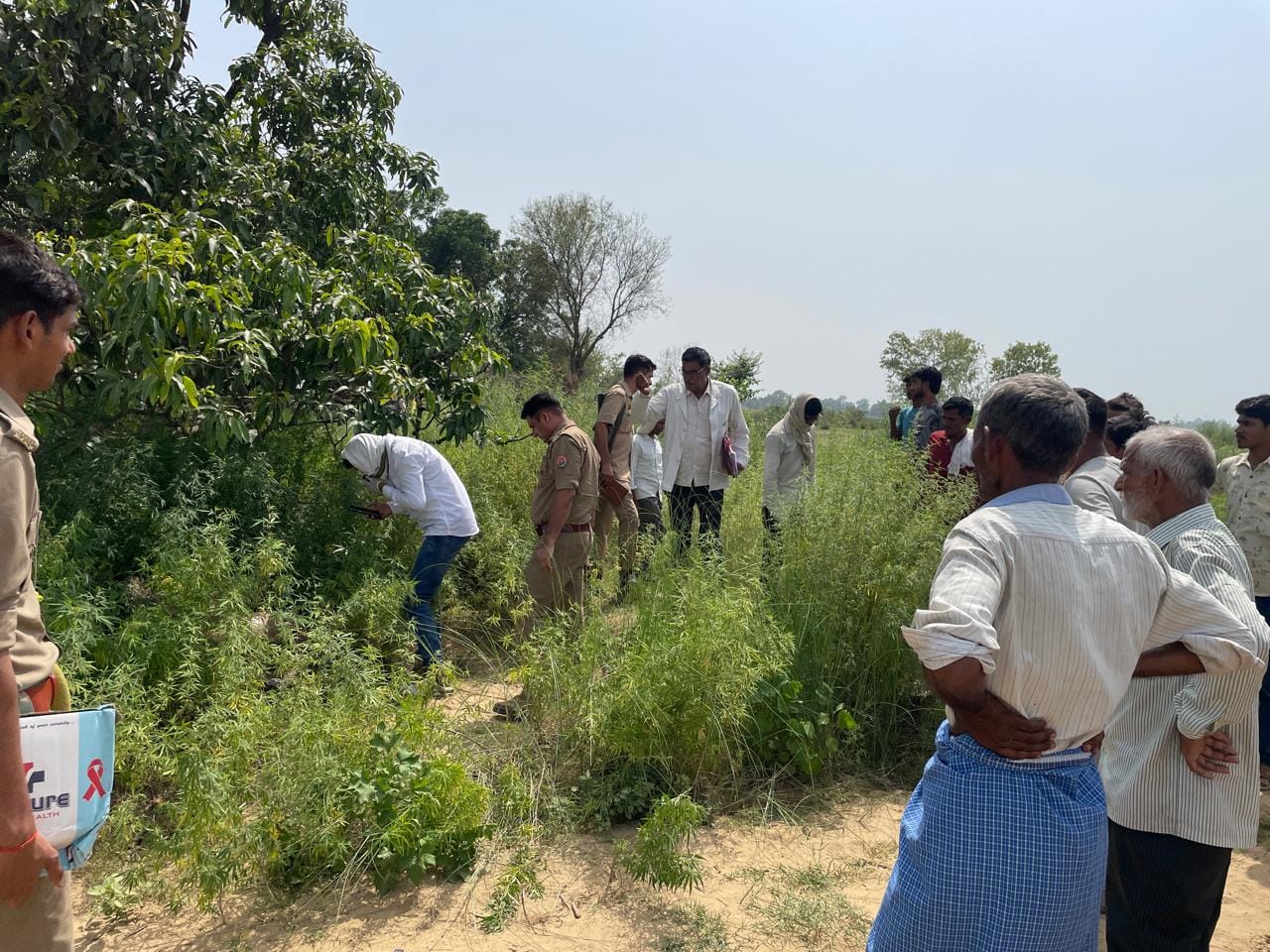 फोटो-16 गांव बरखेड़ा में युवक का शव मिलने के बाद छानबीन करती पुलिस व लगी भीड़। संवाद