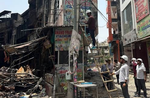 31-रोहतक डी पार्क अग्निकांड के दो दिन बाद बिजली सुधार कार्य करते बिजली निगम के कर्मचारी। संवा