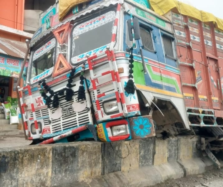 Out-of-control truck damaged after mounting the divider.