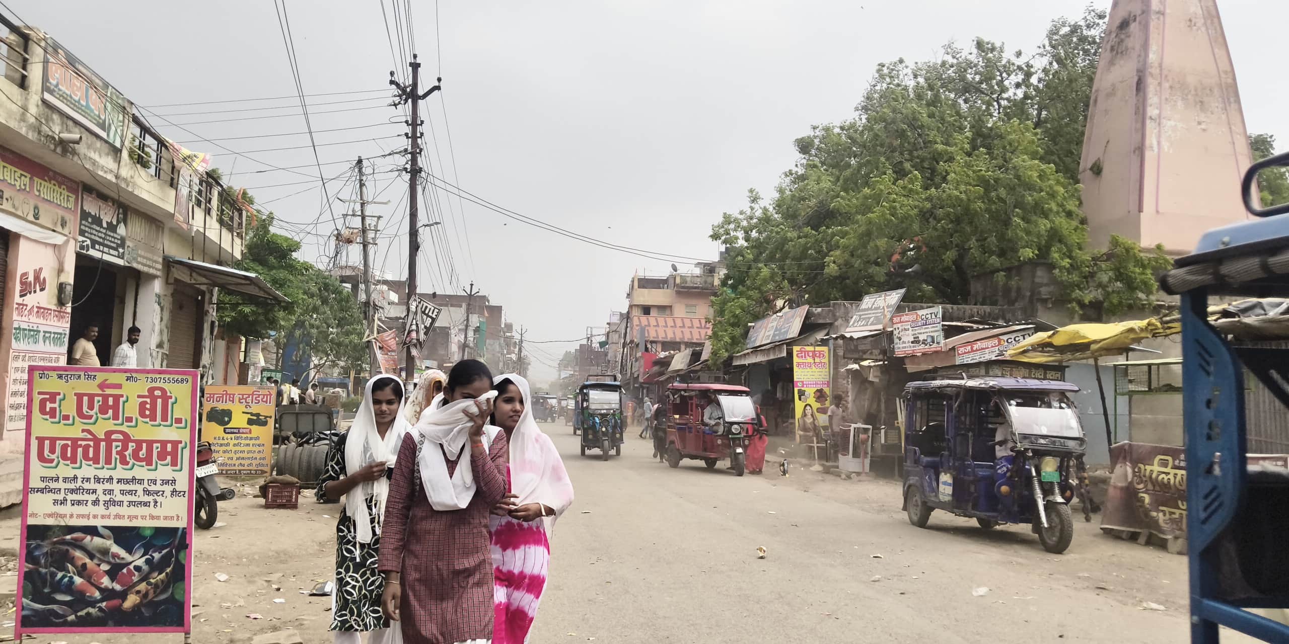 रॉबर्ट्सगंज में हवा से हल्की धूल उड़ने पर चेहरा ढककर जाती युवतियां। संवाद