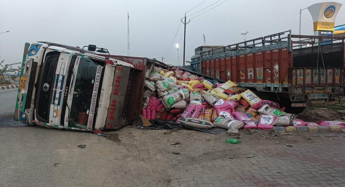 Truck overturns on highway; spices scattered on the road.
