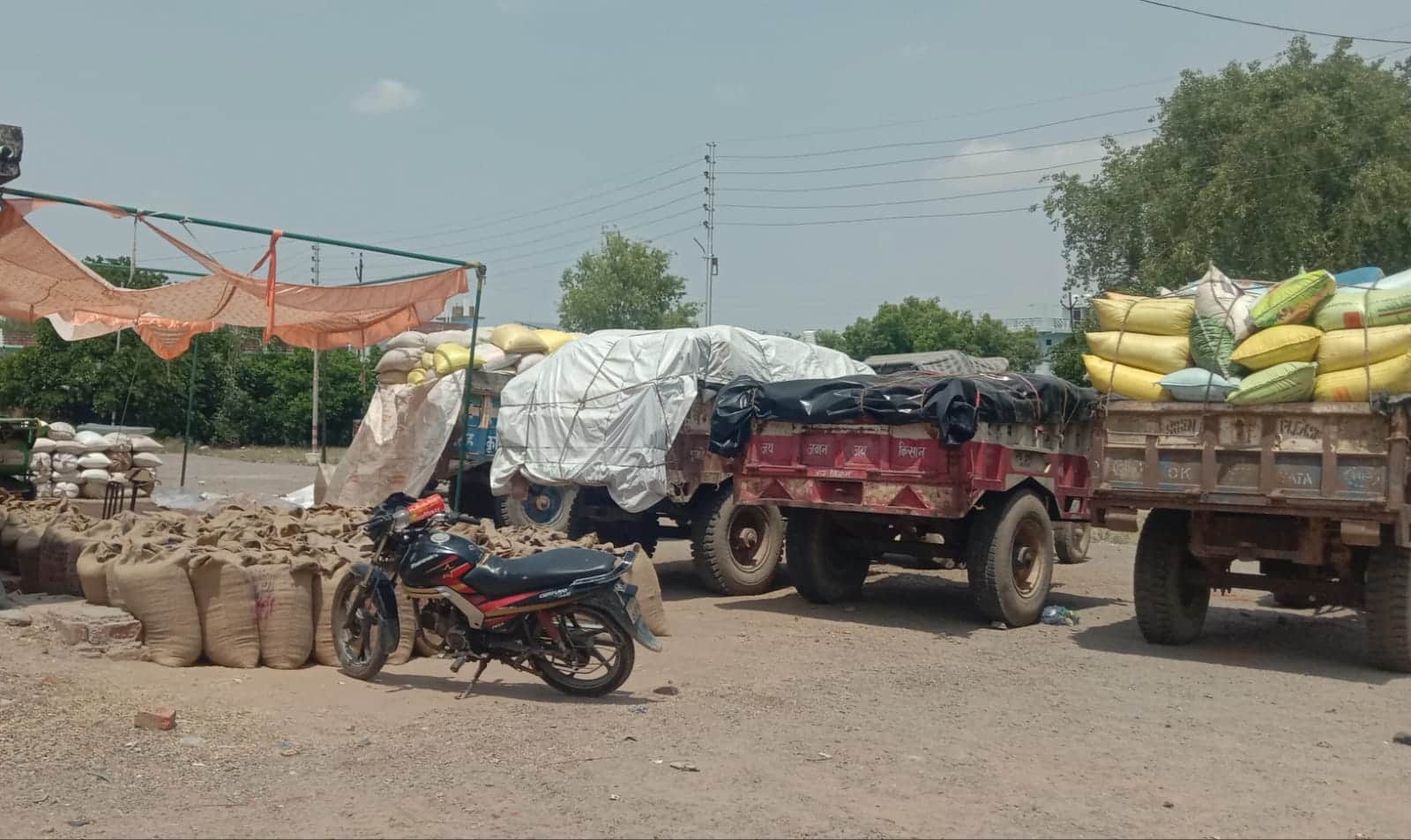 फोटो - 04 तिंदवारी रोड मंडी समिति के पीसीएफ क्रय केंद्र में खड़े ट्रैक्टर। संवाद
