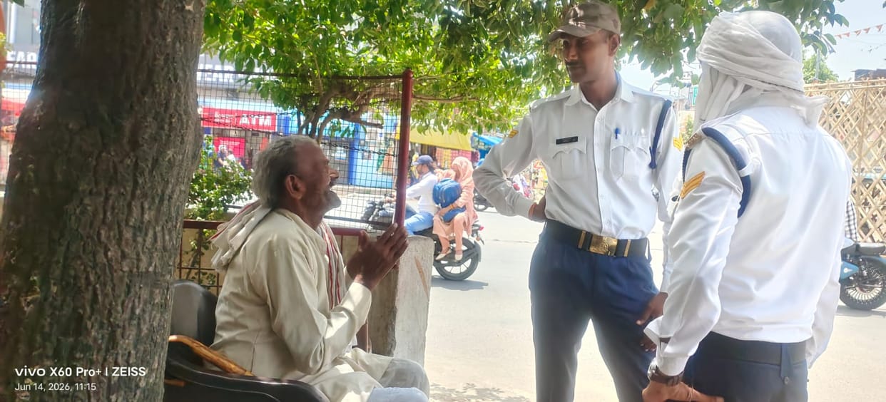Elderly man collapses at intersection; traffic personnel come to his aid.