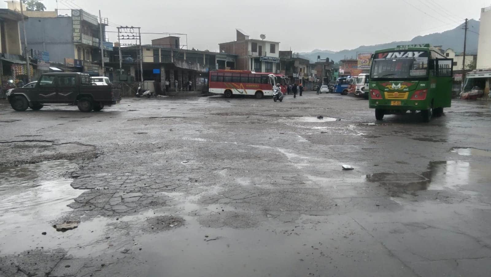 जाहू बस अड्डे में बने गड्ढों में भरा बारिश का पानी। संवाद