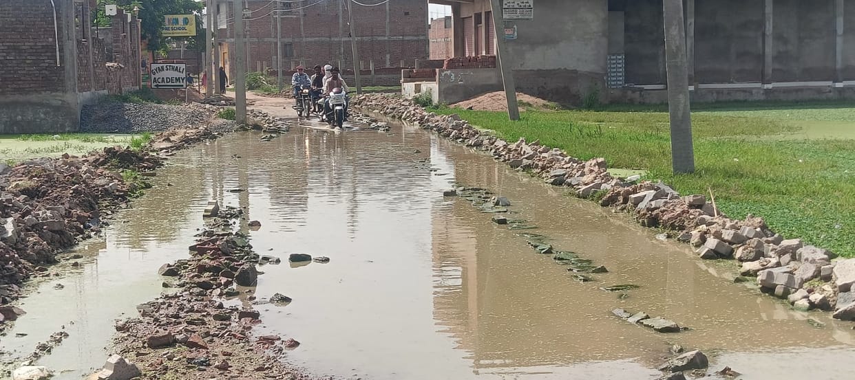 Waterlogging on roads in Ambedkar Nagar due to failure to construct a drain.