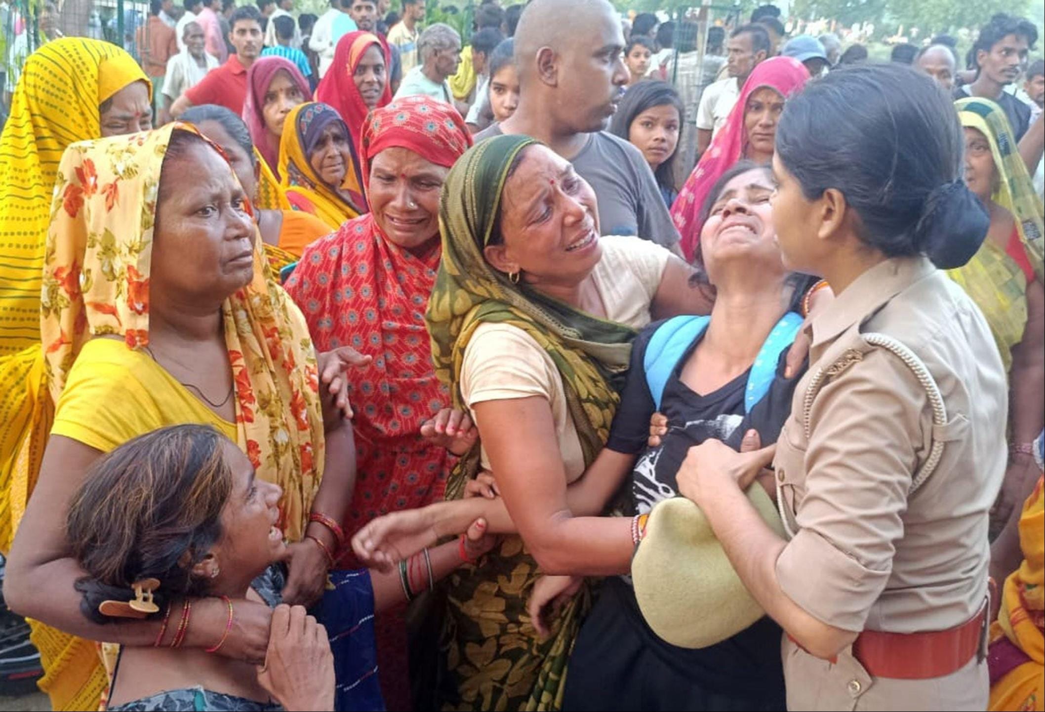 युवक की मौत के बाद रोत-बिलखते परीजन को संभालती आरक्षी। संवाद
