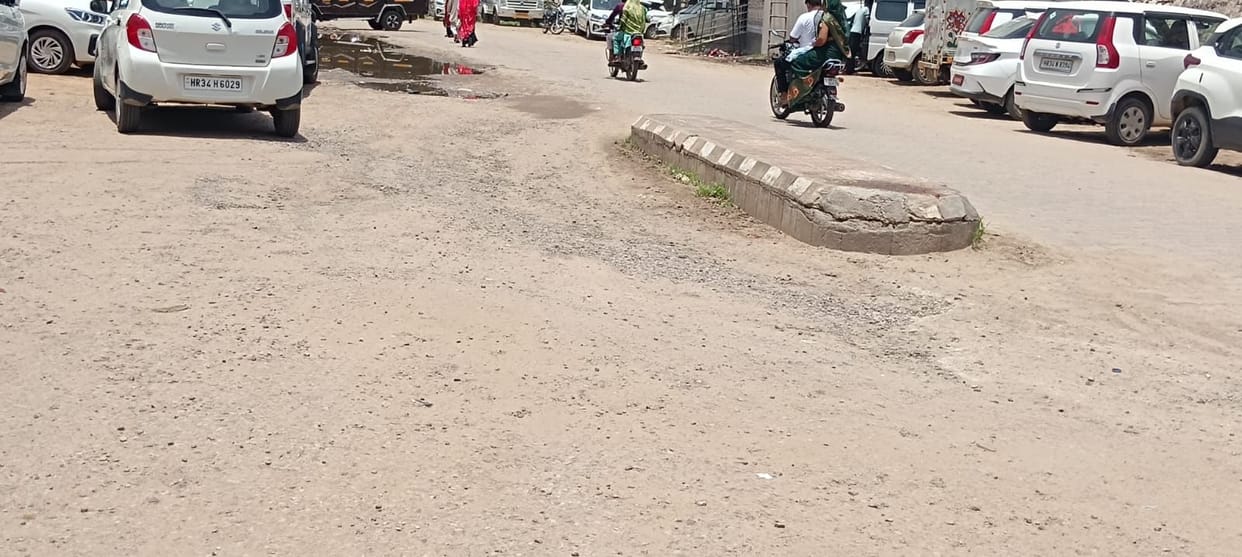 Officials drive over potholes and get jolted every day, yet the road remains unbuilt.