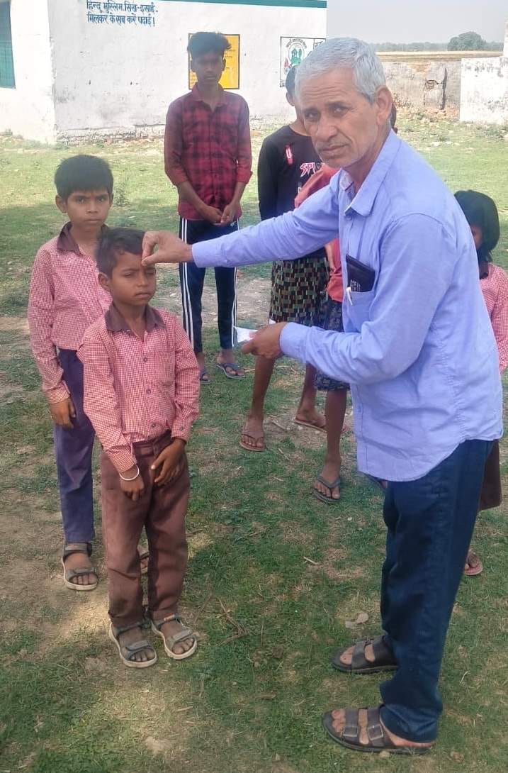 Children arriving at school after 27 days were welcomed with a tilak.