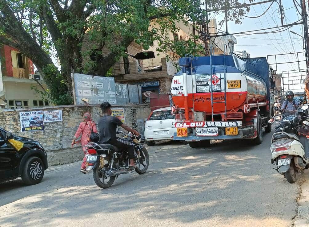 दौलतपुर बाज़ार में सड़क किनारे बेतरतीव खड़े वाहन। संवाद