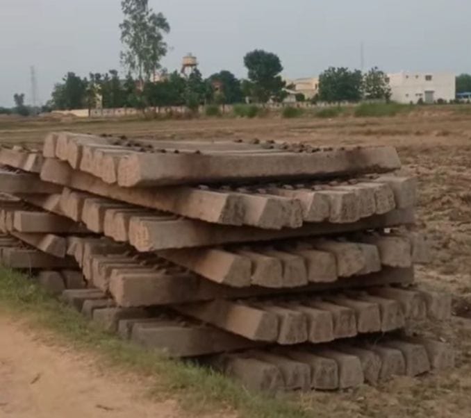 Railway line construction in Dumariyaganj gains momentum; concrete sleepers unloaded.