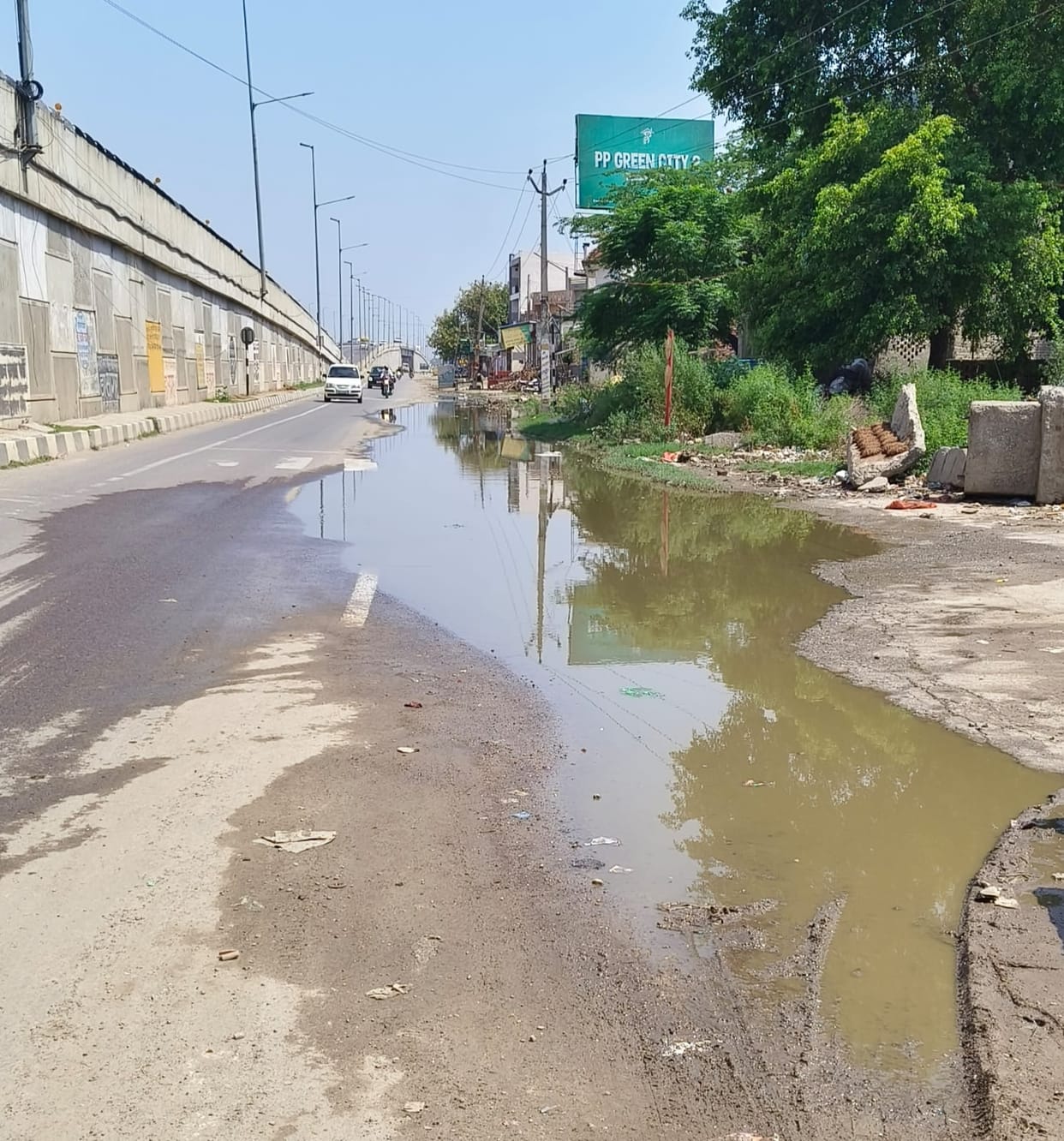 The service lane is filled with water due to the drain being clogged with dirt.