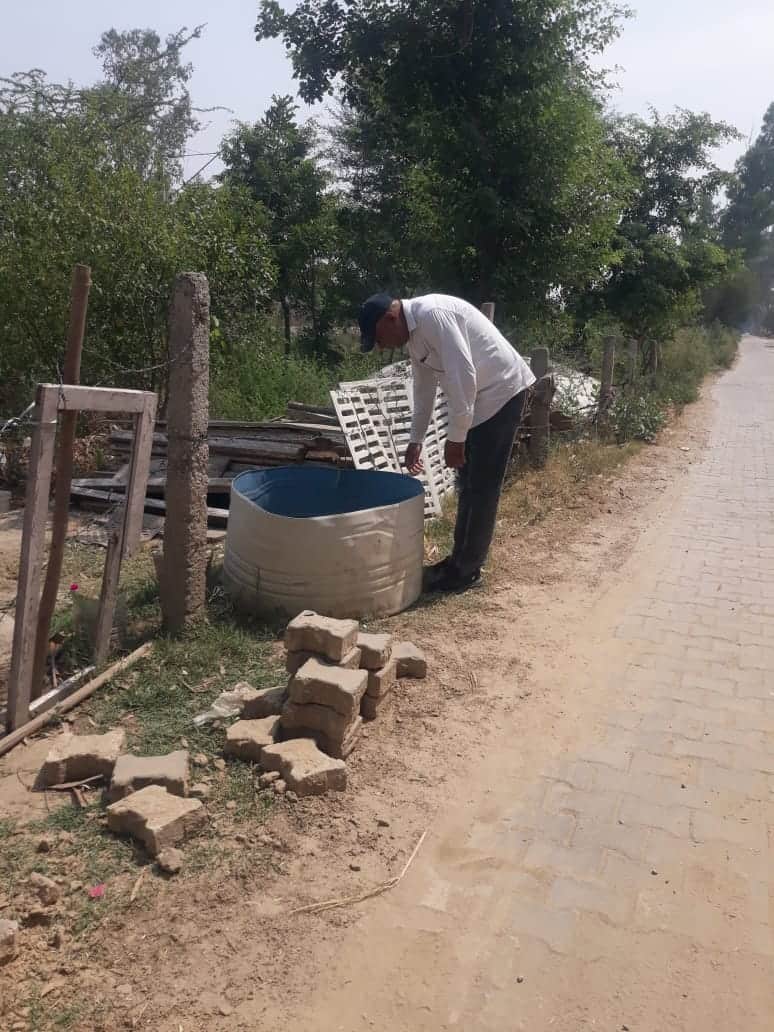 टैंक में पड़े पानी में डेंगू के लारवा की जांच करते हुए स्वास्थ्य कर्मचारी। स्वयं