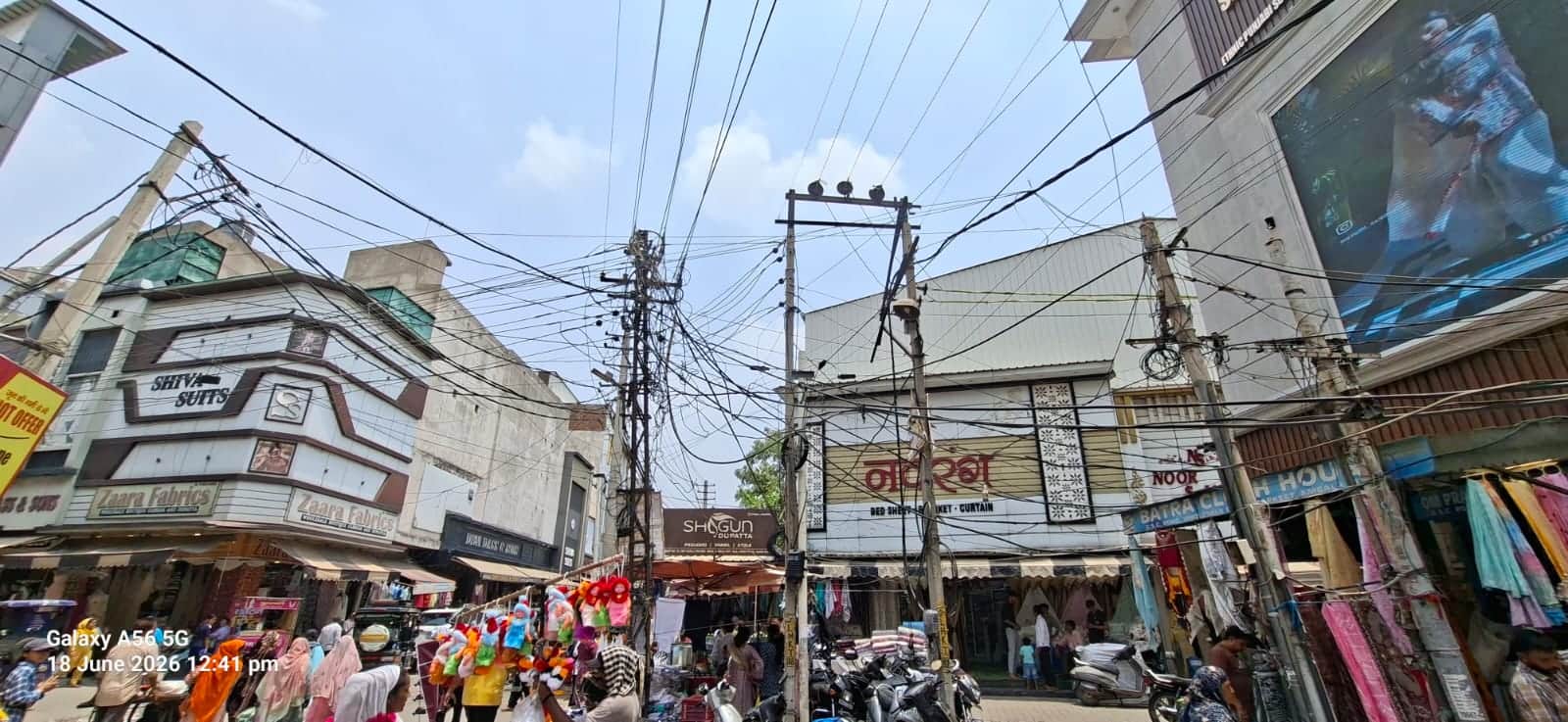 कपड़ा मार्केट में बीच चौराहे पर लटकते तार। संवाद