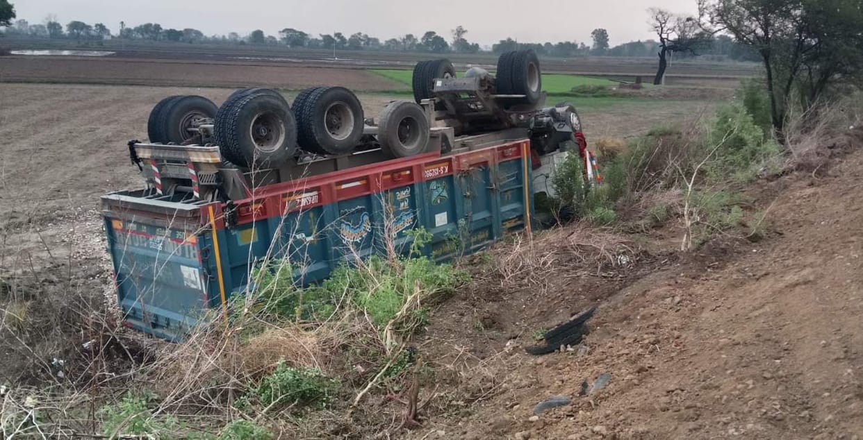 Gravel-laden dumper loses control and overturns into a ditch.