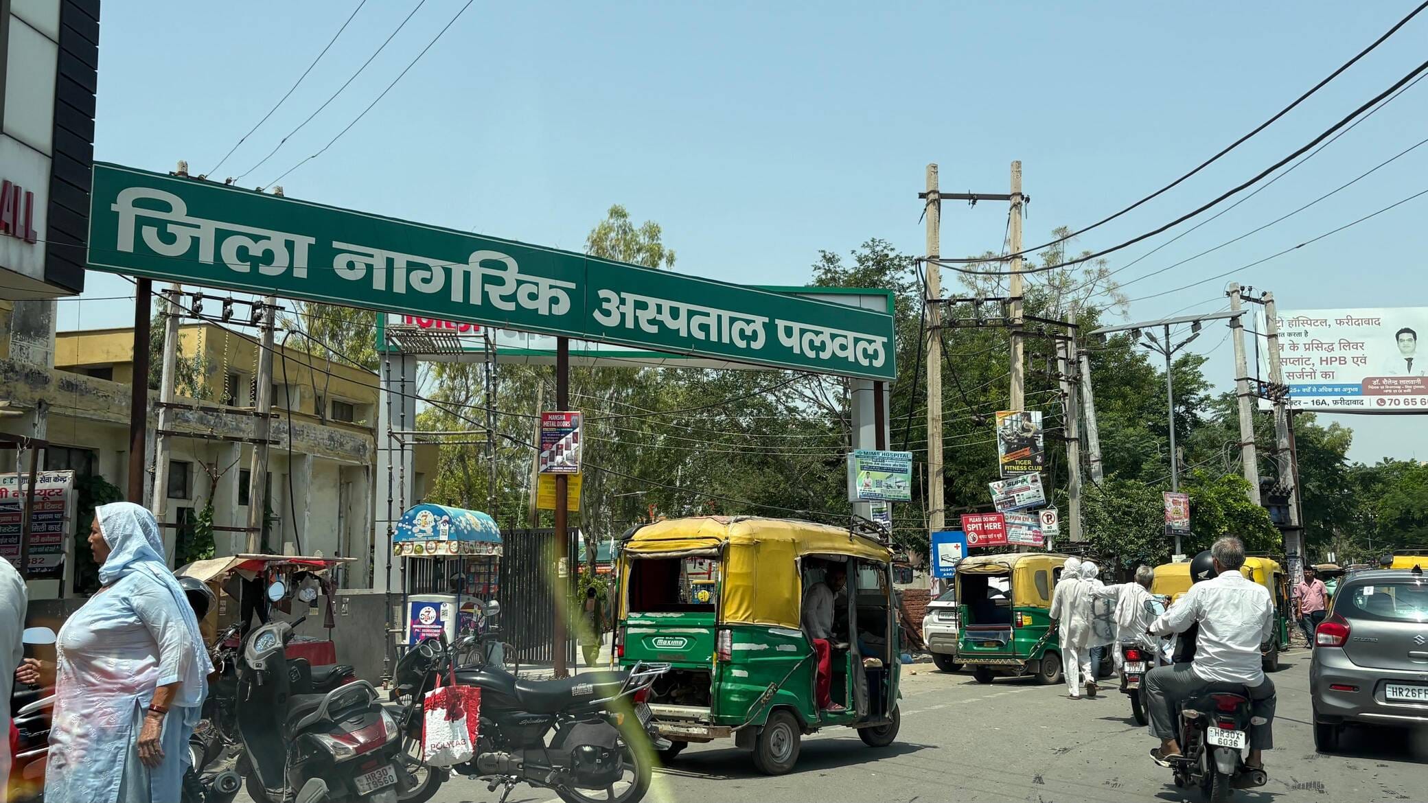 अस्पताल के मुख्य द्वार के सामने खड़े ऑटो। संवाद