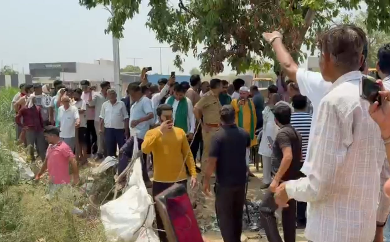 Farmers lay down in front of the JCB machine belonging to the team that had arrived to take possession of the land.
