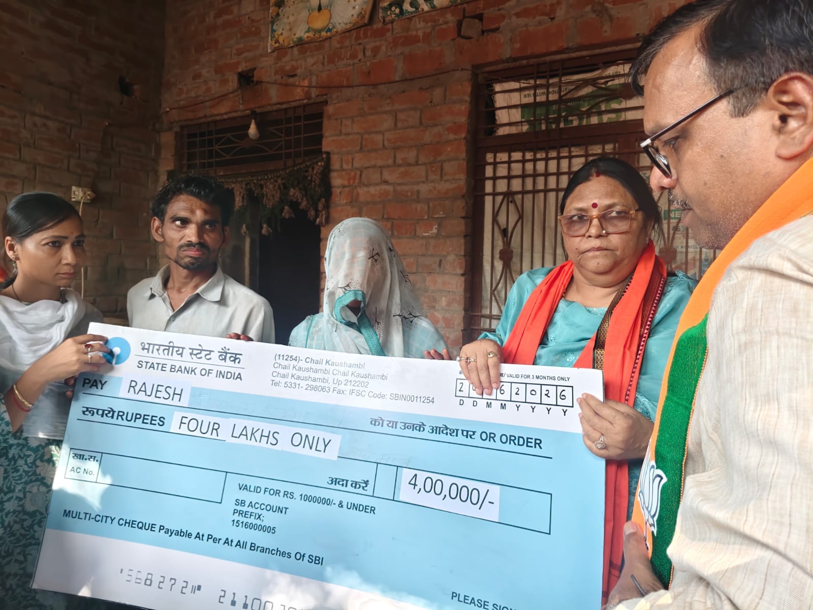 नेवादा गांव में मृतक मासूमों के परिवार को आपदा राशि का चेक देतीं प्रभारी मंत्री कृष्णा पासवान। 