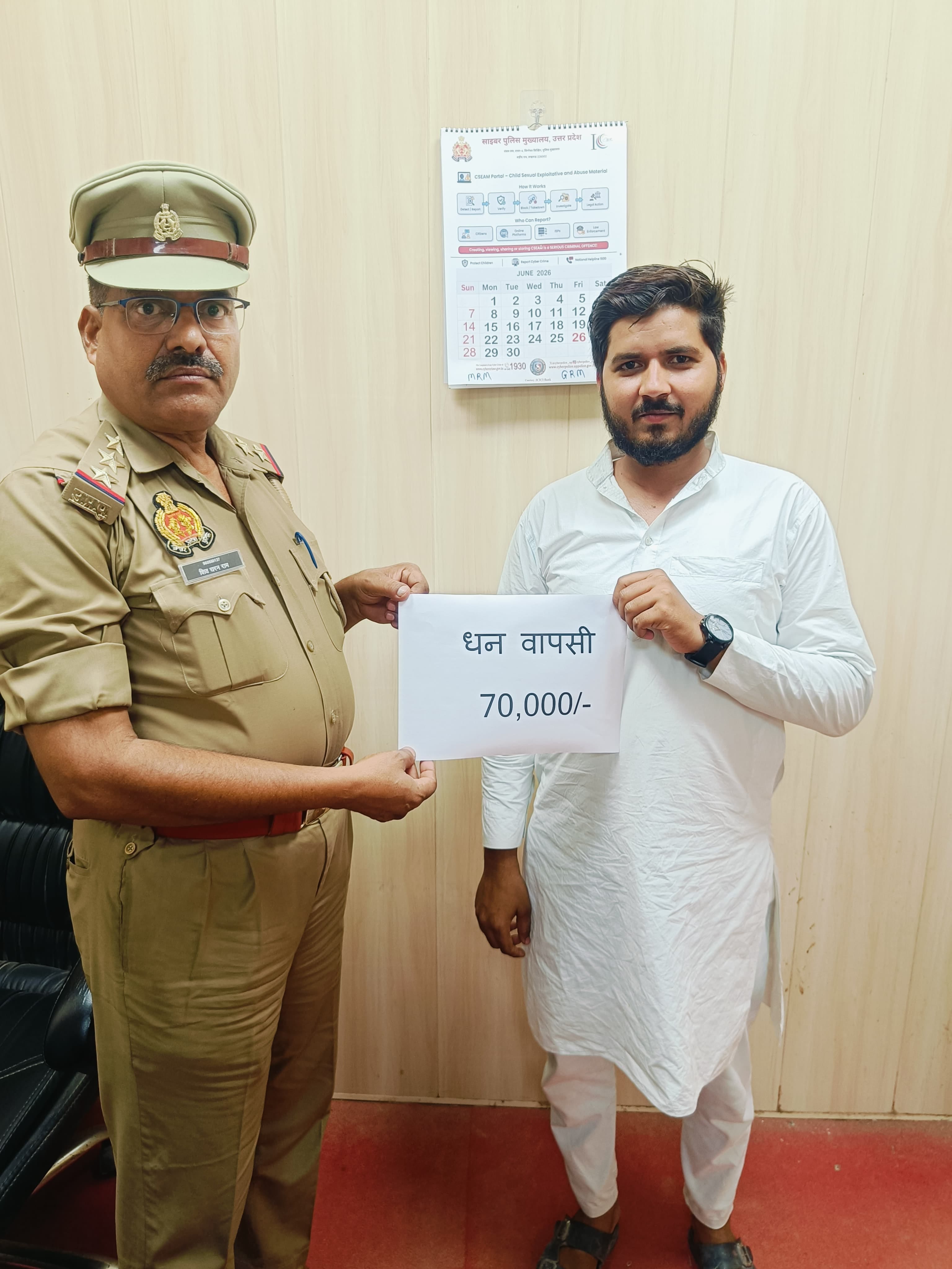 यूपीआई धोखाधड़ी के बाद पीड़ित युवक का डमी पैसा लौटाते पुलिस कर्मी। स्रोत: पुलिस