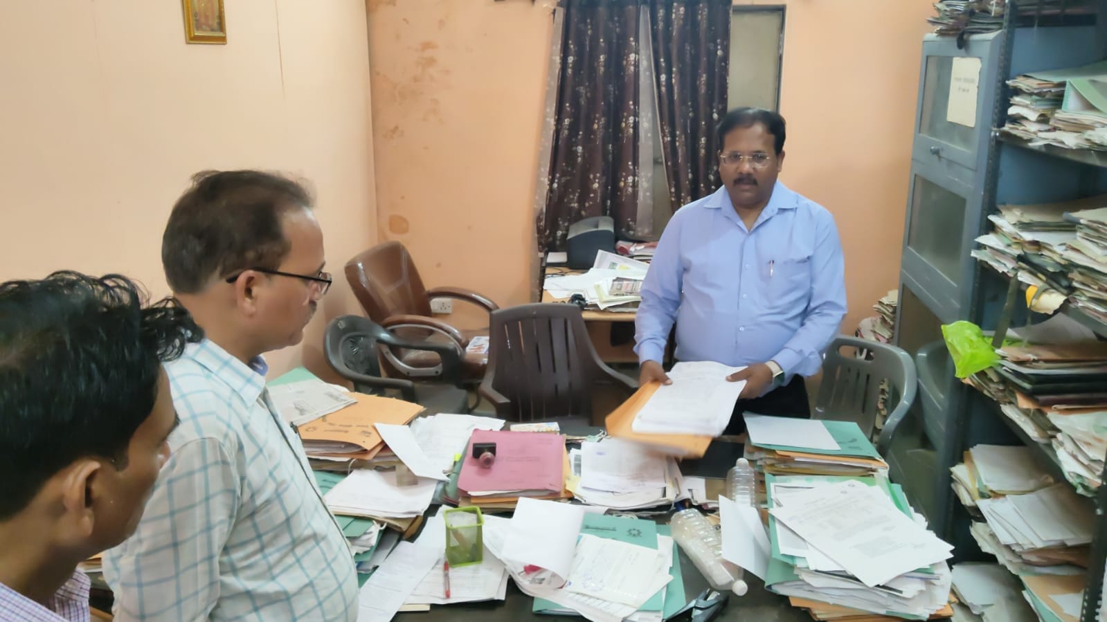 फोटो-32-बीएसए कार्यालय में शनिवार को फाइलें खंगालते नगर मजिस्ट्रेट संजय कुमार व मौजूद कर्मचारी।