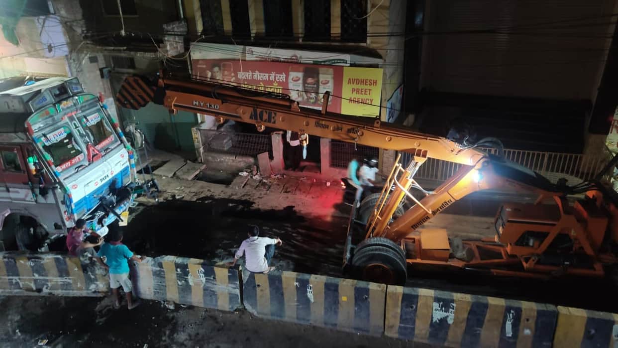 Truck hits divider; oil spills onto the road after fuel tank ruptures.
