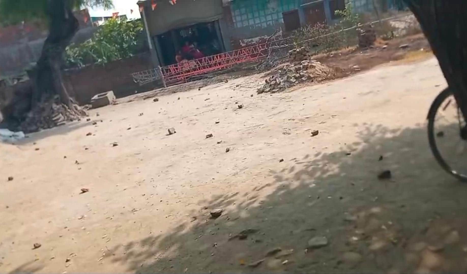 पथराव के बाद सड़क पर पड़े ईंट-पत्थर।