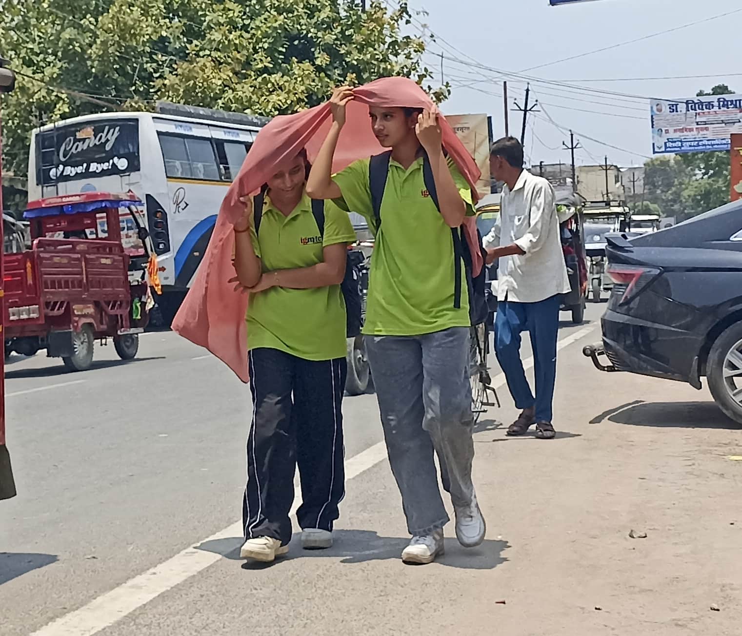 चिलचिलाती धूप से बचने के लिए दुपट्टा ओढ़कर जाती युतियां।संवाद