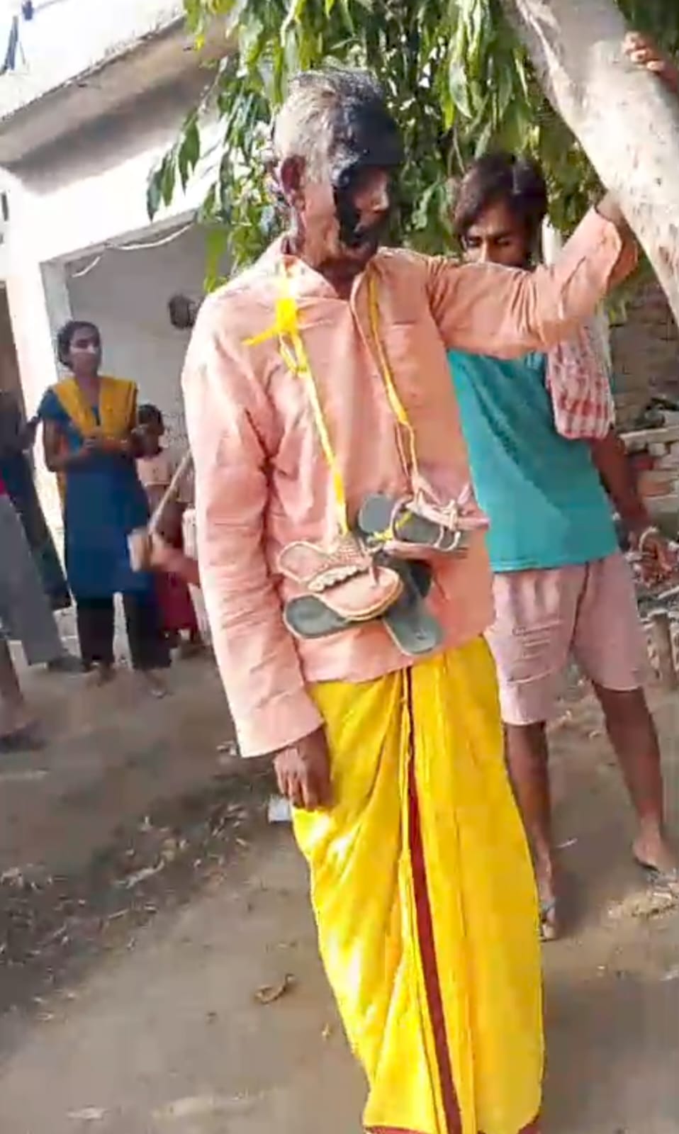 Elderly man's face blackened, garlanded with shoes, and paraded through the village.