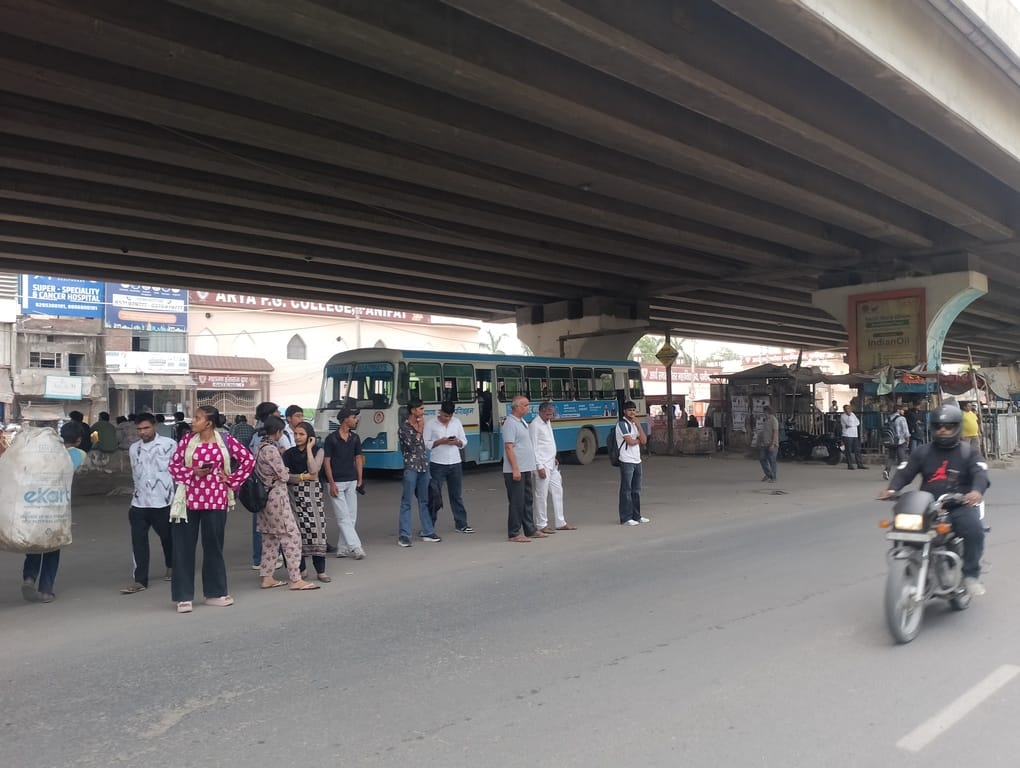 जीटी रोड फ्लाईओवर के नीचे बस के इंतजार में खड़े यात्री।संवाद