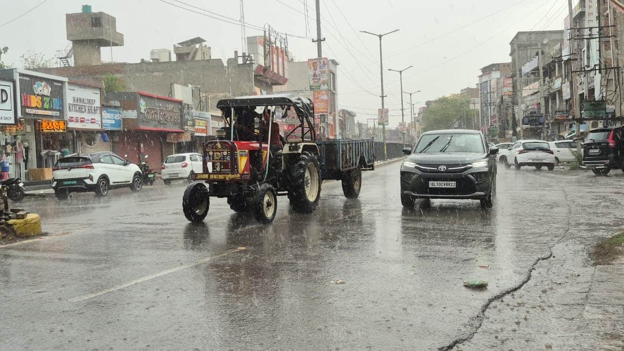 शहर के हांसी गेट पर बारिश में से गुजरते वाहन।