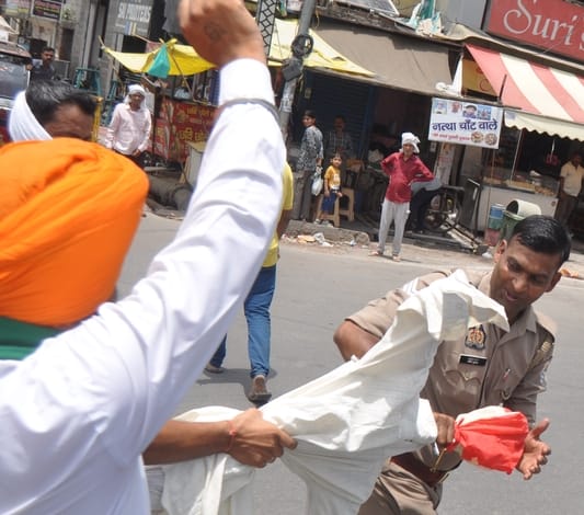तहसील चौराहे पर भाकियू कार्यकर्ताओं से उत्तराखंड सरकार का पुतला छीनते पुलिसकर्मी।संवाद