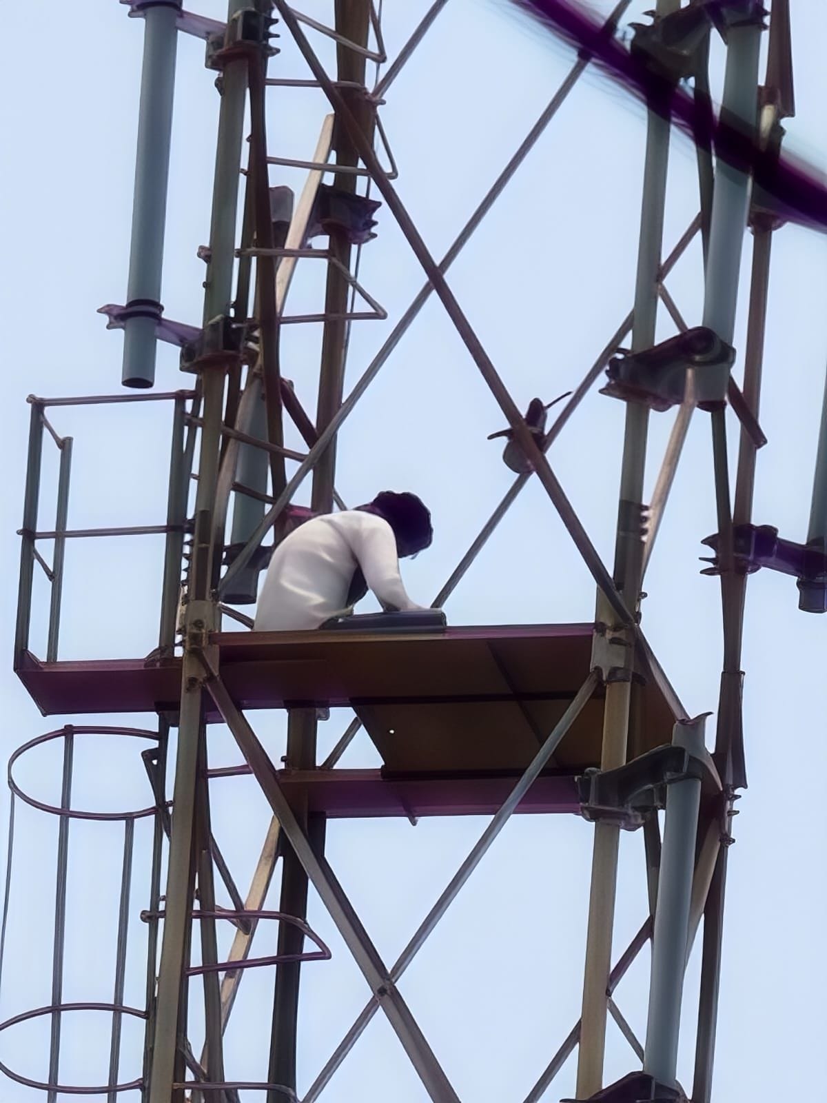 Young man smitten with brother's sister-in-law climbs mobile tower.