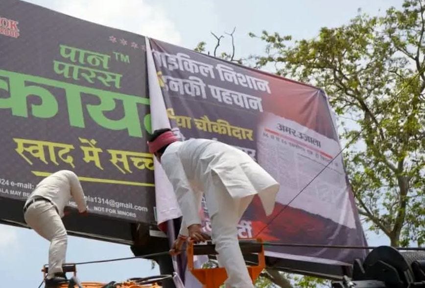 वैदेही वाटिका के पास हैड्रा पर चढ़कर विवादित होर्डिंग्स हटाते सांसद आनंद भदौरिया व कार्यकर्ता। 