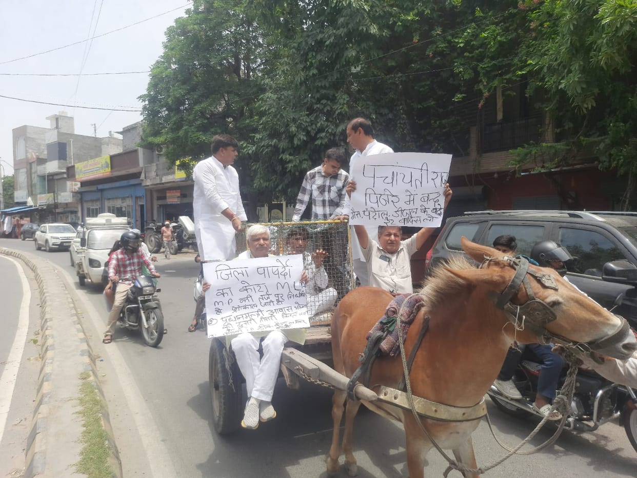 Chained and caged, protest demanding development funds and pensions